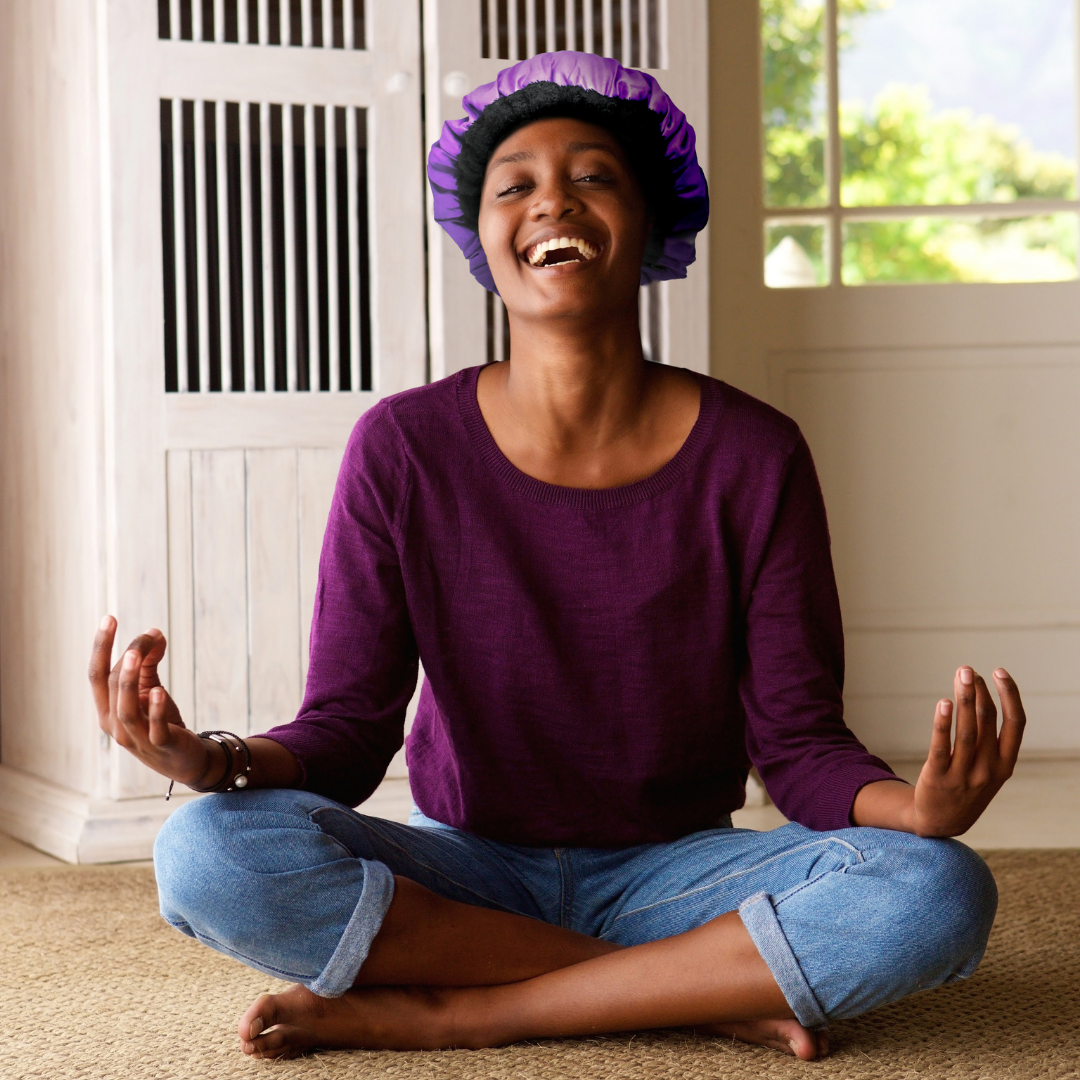 Woman doing yoga while wearing a purple Lava Cap microwavable heat cap UK for deep conditioning dry hair
