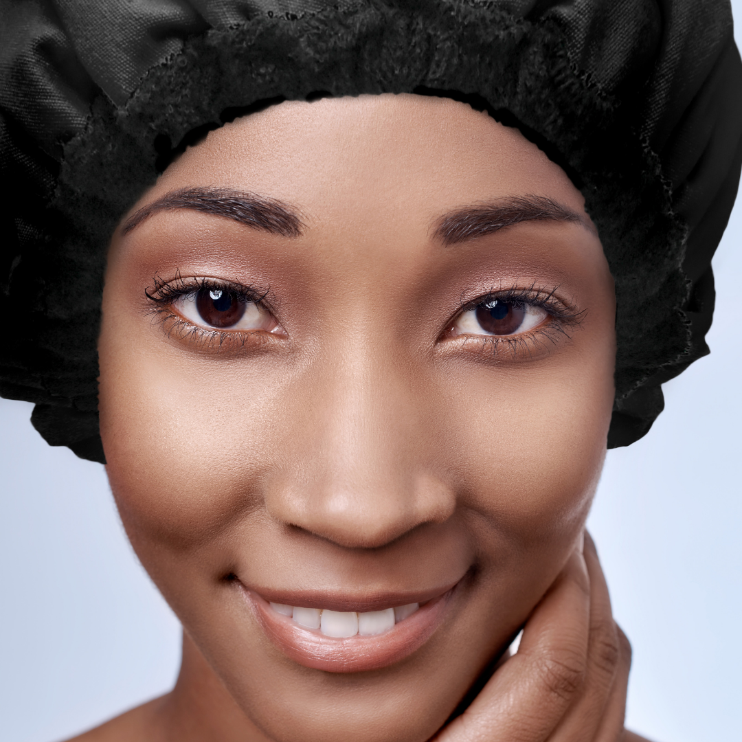 Smiling woman wearing a black Lava Cap hair cap microwavable conditioning cap for fixing dry hair